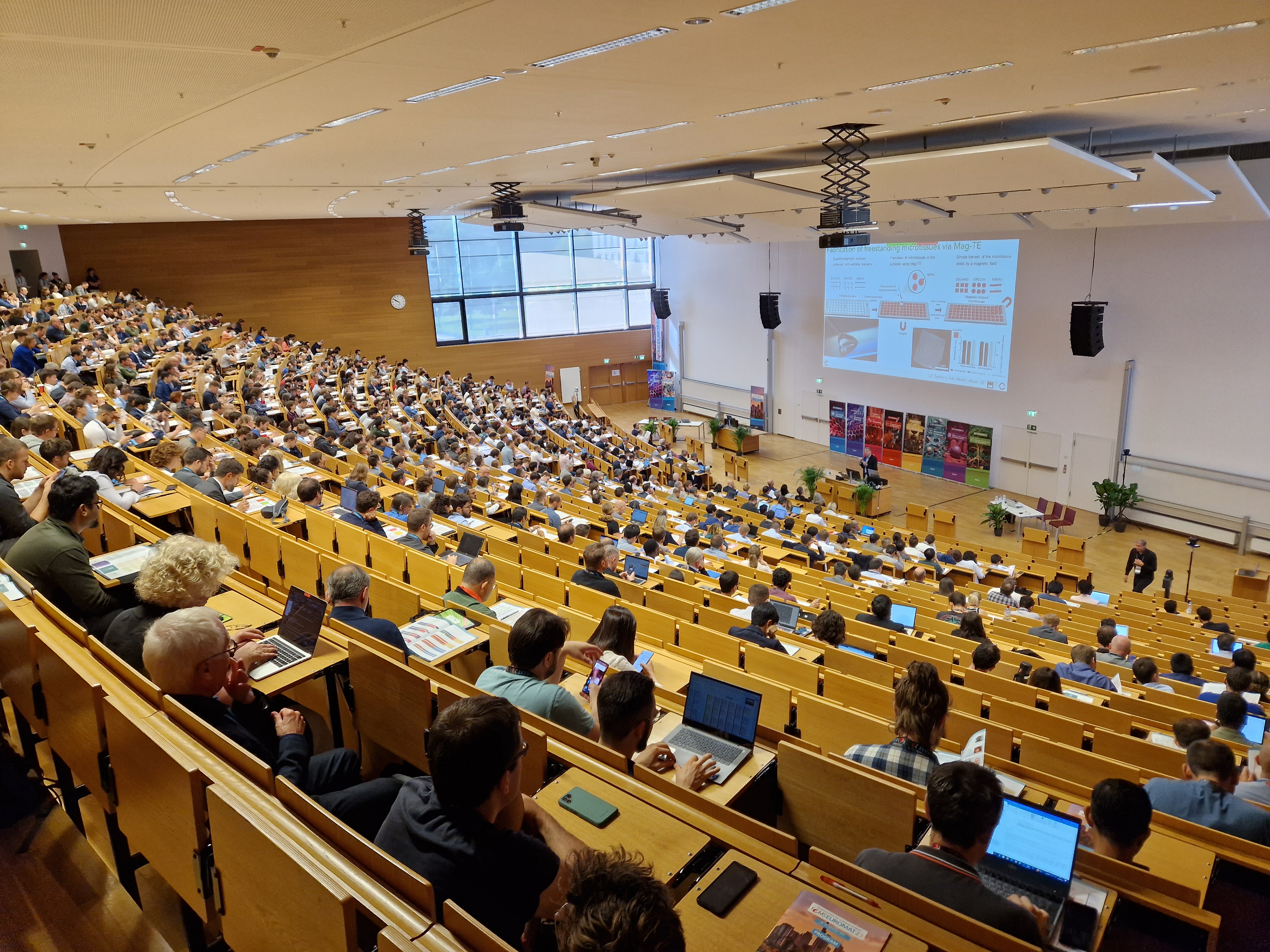 Vollbesetzter Hörsaal bei einem wissenschaftlichen Vortrag